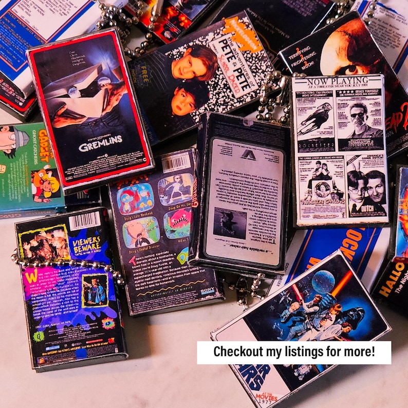 May include: A collection of vintage VHS tapes featuring various movie titles, including "Gremlins", "The Adventures of Pete & Pete", "Ghost Catchers", "Now Playing", and "Star Wars". The tapes are arranged in a pile and some are partially visible. The tapes are all in various colours and have different designs.