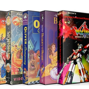 May include: A collection of VHS tapes featuring various animated films and television shows, including 'Transformers', 'Thundercats', 'Oliver & Company', 'Beauty and the Beast', and 'Voltron: Defender of the Universe'.