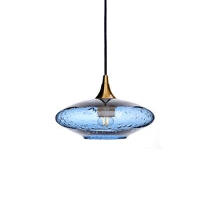 May include: A blue glass pendant light with a gold finish and a textured surface. The light is hanging from a black cord.