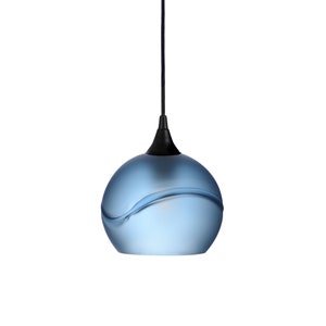 May include: A blue glass pendant light with a black cord and a wavy design.