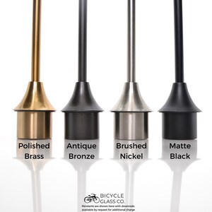 May include: Four different finishes for a pendant light fixture: polished brass, antique bronze, brushed nickel, and matte black.