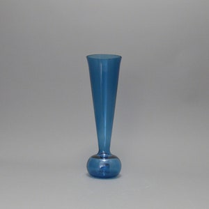 May include: A blue glass bud vase with a round base and a tall, narrow neck.
