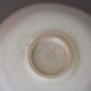 May include: A close-up of the bottom of a white ceramic bowl with a brown mark around the edge. The bowl has a circular mark in the center with the text "R.S. 41" in the center.