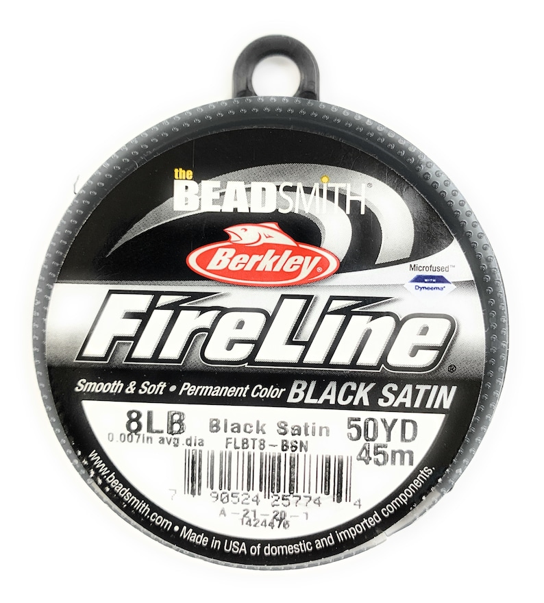 May include: A spool of Berkley FireLine fishing line in black satin. The label reads "8LB Black Satin 50YD" and "0.007in avg. dia." The spool is black with white and red text. The text "Smooth & Soft" is also visible.