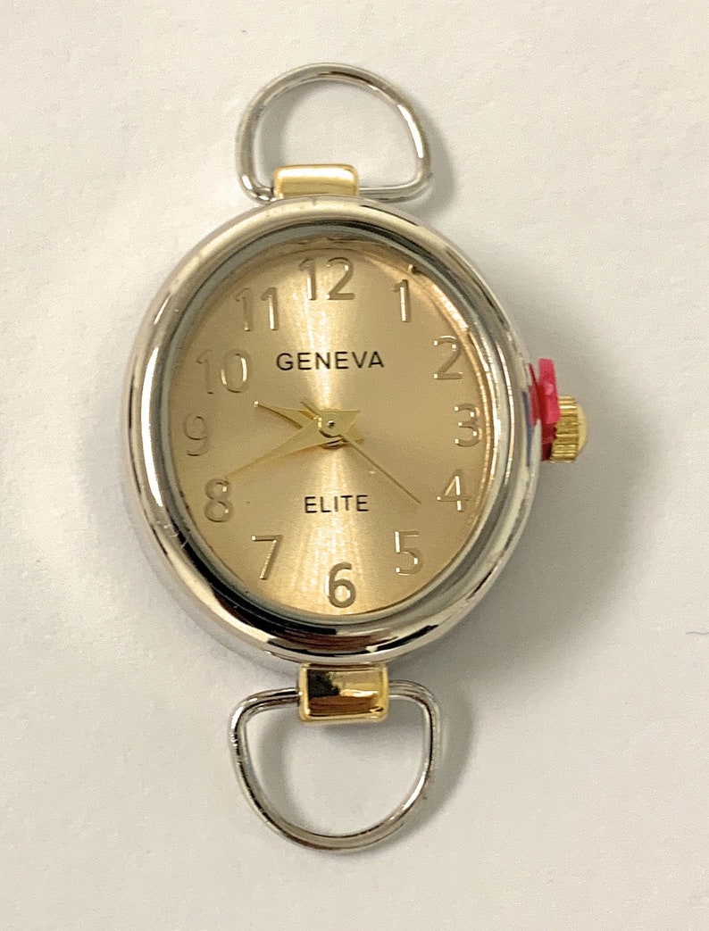 May include: A gold-toned oval watch with a silver trim and two loops. The watch face has black Roman numeral markings and the words "GENEVA" and "ELITE".