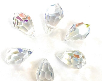 May include: Six clear crystal teardrop shaped prisms with faceted surfaces.