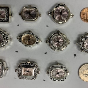 Puede incluir: Una colecci&oacute;n de diez esferas de reloj plateadas con varias formas y dise&ntilde;os decorativos. Las esferas del reloj tienen esferas de color rosa claro y manecillas negras. Se incluye una moneda de un centavo y una moneda de veinticinco centavos para comparar el tama&ntilde;o.
