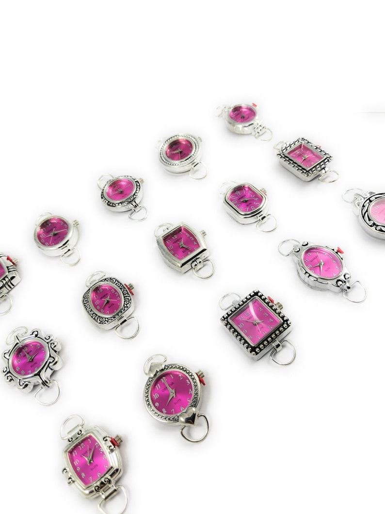 May include: Assortment of silver-toned wristwatches with pink faces. The watches have different shaped cases and are arranged in a row on a white background.