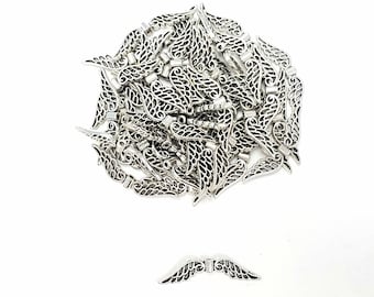 May include: A pile of silver-toned metal angel wings charms. The wings are intricately detailed with a delicate, feathery design.