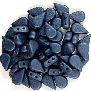 May include: A pile of dark blue teardrop-shaped beads with two holes each. The beads have a matte finish and a slightly textured surface.