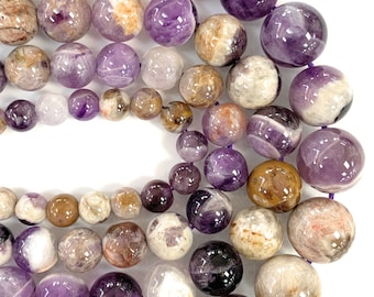 May include: A strand of round, purple amethyst beads with brown and white inclusions. The beads are various shades of purple, brown, and white.