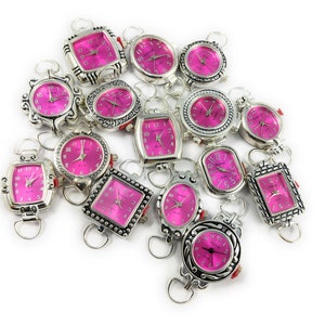 May include: A collection of 15 silver-tone wristwatches with pink faces. The watches have different styles of cases and bands.