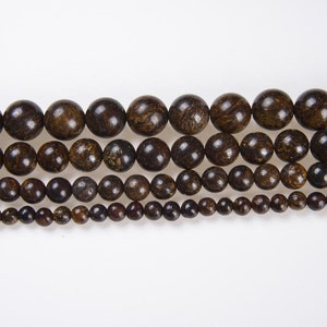 May include: A strand of brown gemstone beads in various sizes. The beads are round and have a speckled appearance.