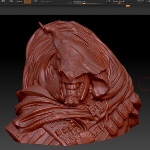 May include: A detailed, reddish-brown 3D-printed bust of a character with a hooded cloak and a sinister grin. The bust features intricate details, including the texture of the cloak and the character's facial features. The character has a beard and is wearing a belt with pouches.