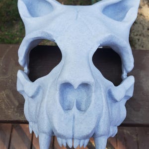 K&ouml;nnte beinhalten: Eine detaillierte Tier Sch&auml;delmaske in hellblau mit scharfen Z&auml;hnen. Die Maske ist aus einem strukturierten Material gefertigt und hat ein realistisches Aussehen.