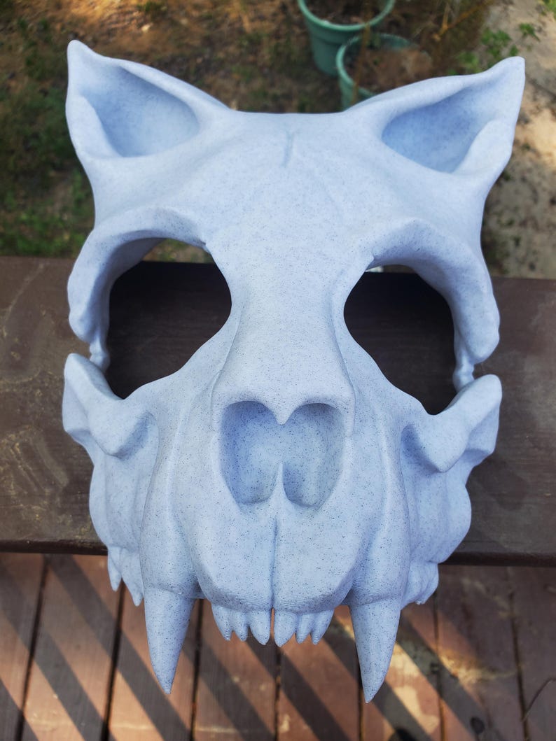 K&ouml;nnte beinhalten: Eine detaillierte Tier Sch&auml;delmaske in hellblau mit scharfen Z&auml;hnen. Die Maske ist aus einem strukturierten Material gefertigt und hat ein realistisches Aussehen.