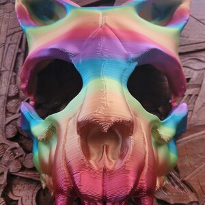 K&ouml;nnte beinhalten: Eine regenbogenfarbene 3D-gedruckte Tier Sch&auml;delmaske. Die Maske ist aus Kunststoff und hat ein detailliertes Design. Der Sch&auml;del ist ein Wolf- oder Hundesch&auml;del mit scharfen Z&auml;hnen.