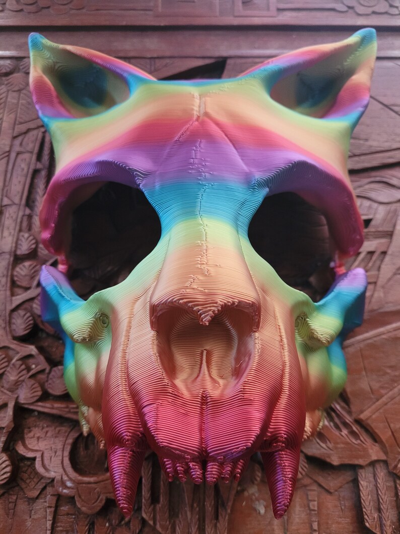 K&ouml;nnte beinhalten: Eine regenbogenfarbene 3D-gedruckte Tier Sch&auml;delmaske. Die Maske ist aus Kunststoff und hat ein detailliertes Design. Der Sch&auml;del ist ein Wolf- oder Hundesch&auml;del mit scharfen Z&auml;hnen.