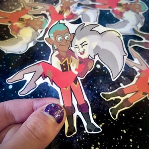 May include: A sticker featuring a cartoon couple, a man with green hair and glasses holding a woman with gray hair. The woman is wearing a red dress and the man is wearing a red and gold uniform. The sticker is on a black and white background.