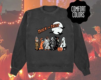 Bluza z nadrukiem „Cukierek albo psikus” na Halloween • Klasyczny dziecięcy kostium z okrągłym dekoltem • Jesienny sweter w wygodnych kolorach • Koszula w stylu vintage z motywem upiornego sezonu