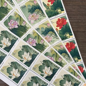 May include: A collection of vintage Chinese postage stamps featuring floral designs. The stamps are printed on white paper with colorful illustrations of flowers and leaves. The stamps are in various sizes and shapes, and some have the text "中国人民邮政" printed on them.