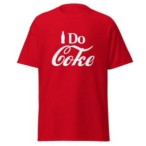 Pode incluir: Camiseta vermelha com um logotipo Coca-Cola branco e o texto "I Do Coke".