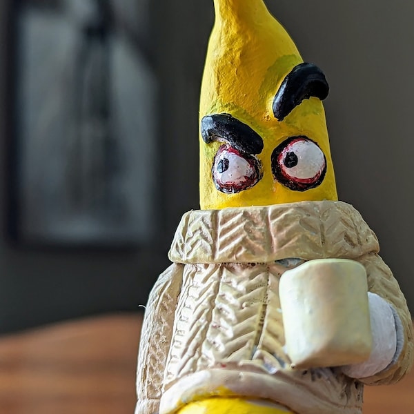 Grumpy Banana wearing a comfortable sweater drinking coffee