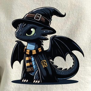 Puede incluir: Ilustración de dibujos animados de un dragón negro con un sombrero de bruja con una correa y hebilla marrón, una bufanda con rayas amarillas y negras y una túnica negra con un emblema dorado "R". El dragón tiene ojos verdes y alas negras.