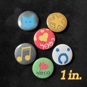May include: A collection of six round pinback buttons, each approximately 1 inch in diameter. The buttons feature various designs, including a pixelated blue cat, a gold star, a red heart, a musical note, a stylized face, and a flower with the text "Neco Corporation".