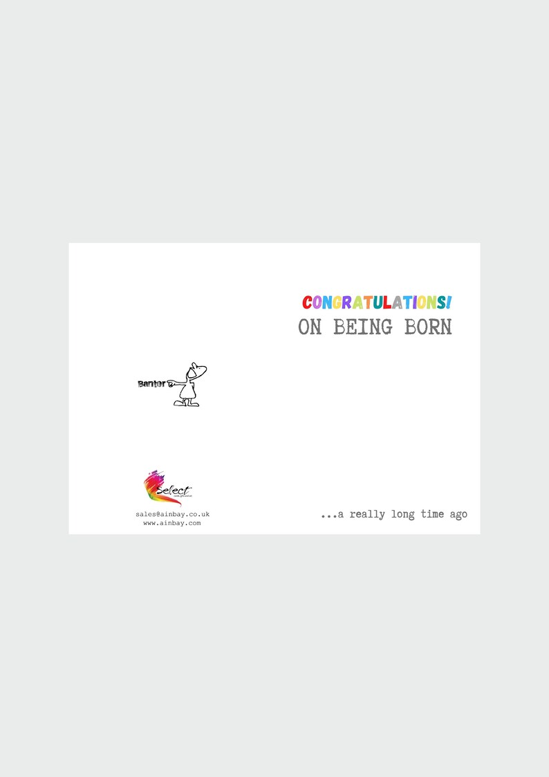 May include: A humorous greeting card with a cartoon stick figure pointing to the text "Congrats! On being born... a really long time ago". The card is white with a rainbow colored logo in the bottom left corner.