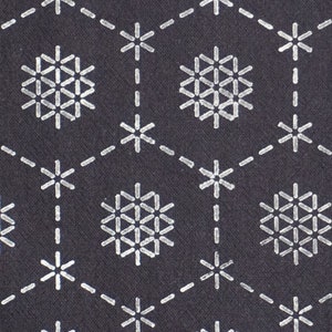 Könnte beinhalten: Ein dunkelgrauer Stoff mit einem sich wiederholenden Muster aus weißen, schneeflockenartigen Designs. Die Schneeflocken bestehen aus kleinen Linien, die eine geometrische Form bilden.