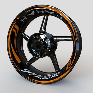 May include: Black motorcycle wheel rim with an orange and black graphic design that says "Joker" and "90ZR".