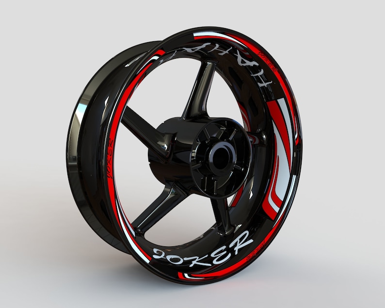 May include: Black motorcycle wheel rim with a red and white graphic design that says "Joker" on the side.