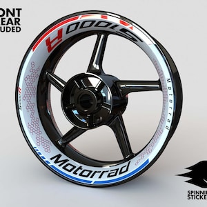 May include: A white motorcycle wheel rim with a red, white and blue graphic design. The graphic includes the word "Motorrad" and a honeycomb pattern.