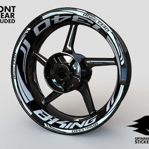 May include: Black motorcycle wheel rim with a white "BKING 1340" sticker on it. The sticker has a white stripe design.
