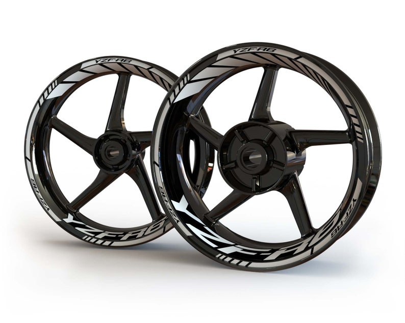 May include: Two black motorcycle wheels with silver YZF-R6 decals. The decals are on the outer rim of the wheels and have a white stripe running along the edge.