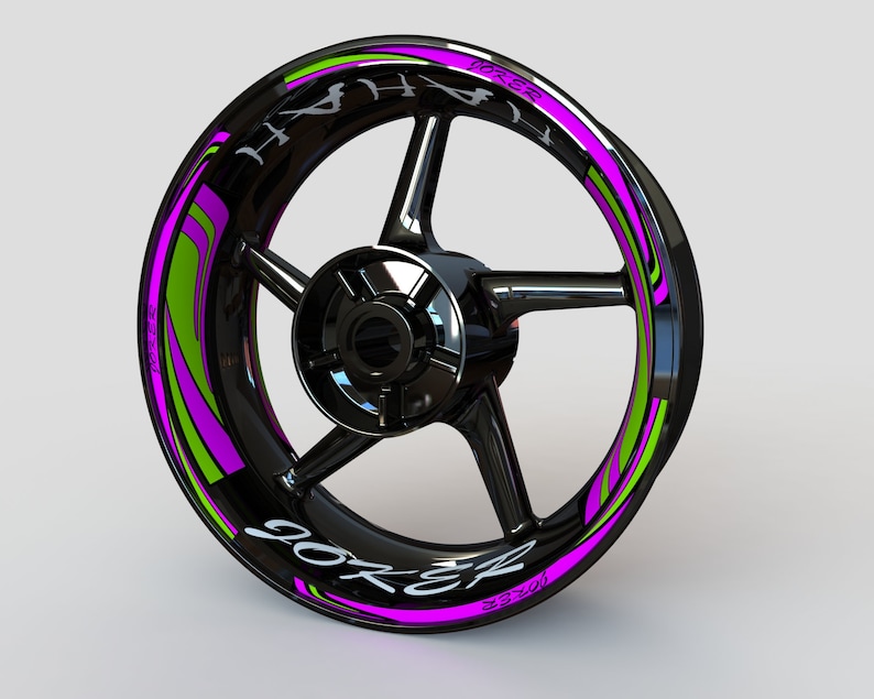 May include: Black motorcycle wheel rim with a pink and green graphic design that says "Joker" and "Torque" on it.
