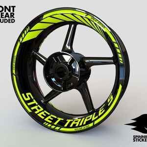 Puede incluir: Una llanta de rueda de motocicleta negra con un dise&ntilde;o de rayas amarillas y negras. La raya tiene el texto "Street Triple" y "Gran Breta&ntilde;a" en ella.
