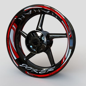 May include: Black motorcycle wheel rim with a red and white graphic sticker that says "Joker" and "Hyper", with a black and silver background.