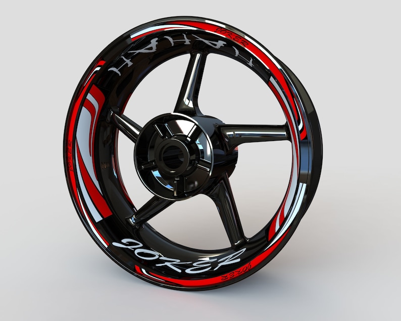 May include: Black motorcycle wheel rim with a red and white graphic sticker that says "Joker" and "Hyper", with a black and silver background.
