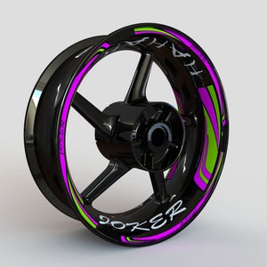 May include: Black motorcycle wheel rim with a pink and green graphic design and the word "JOKER" written on it.