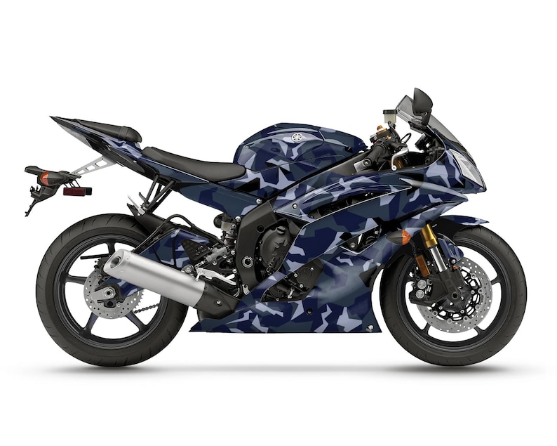 Pu&ograve; includere: Una moto sportiva Yamaha R6 con un motivo mimetico blu e bianco. La moto ha ruote nere, uno scarico argentato e forcelle anteriori dorate. Lo sfondo &egrave; bianco.