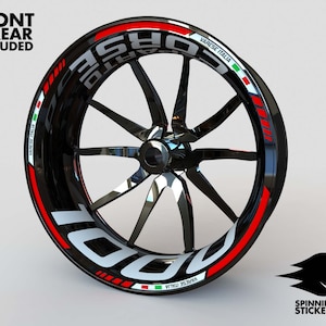 May include: A black motorcycle wheel rim with a white and red sticker that says "CORSI VARESE ITALIA" with the Italian flag on either side of the text.
