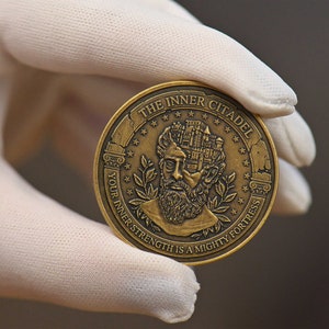 Op de afbeelding: Een ronde, bronskleurige metalen munt met een reli&euml;f van een bebaarde figuur met een kasteel in het hoofd verwerkt. De tekst THE INNER CITADEL en YOUR INNER STRENGTH IS A MIGHTY FORTRESS staat in reli&euml;f langs de cirkelvormige rand.