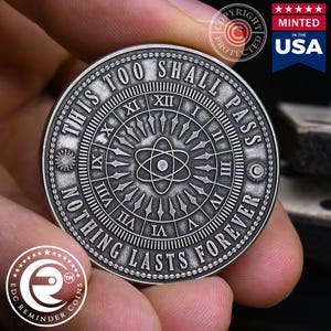May include: A silver-toned round coin with the text "This Too Shall Pass Nothing Lasts Forever" around the edge. The centre of the coin features a clock face with Roman numerals and a stylised atom symbol.