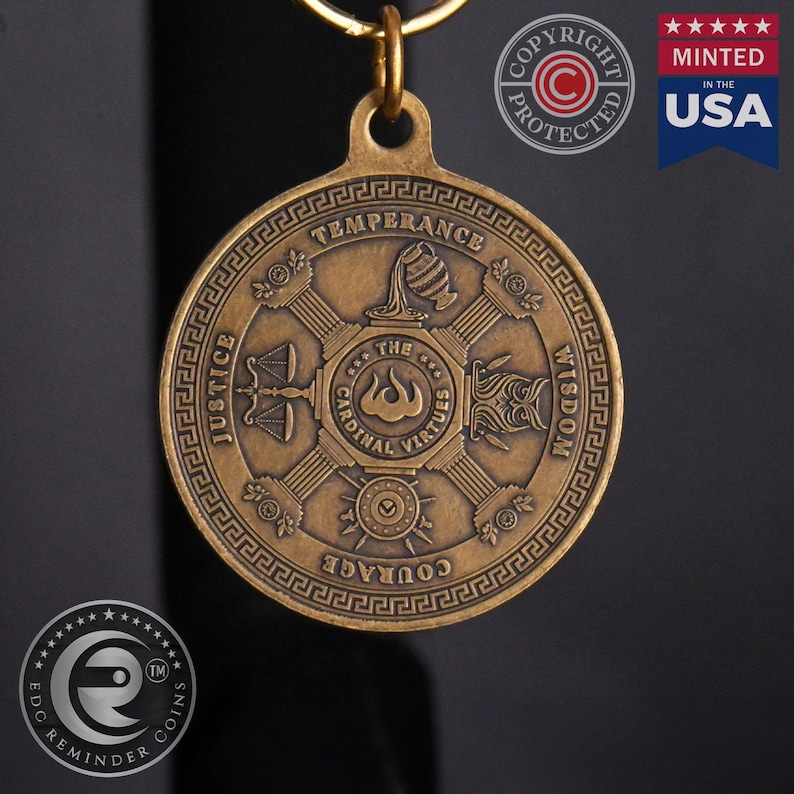May include: A bronze-colored metal keychain with a round pendant featuring the four cardinal virtues: Justice, Temperance, Courage, and Wisdom. The pendant is inscribed with "The Cardinal Virtues" and has a Greek key border.