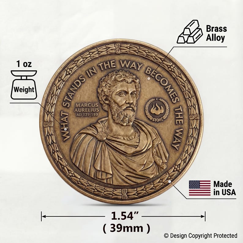 May include: A round brass alloy coin featuring a relief portrait of Marcus Aurelius with the text WHAT STANDS IN THE WAY BECOMES THE WAY, MARCUS AURELIUS AD 121-180, and STOIC. The coin weighs 1 oz and measures 1.54 inches in diameter.