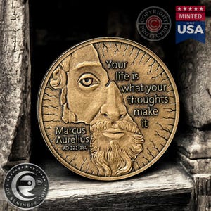 May include: A bronze coin with a portrait of Marcus Aurelius and the quote "Your life is what your thoughts make it". The coin is surrounded by a decorative border and has the words "Marcus Aurelius AD 121-180" inscribed on it.