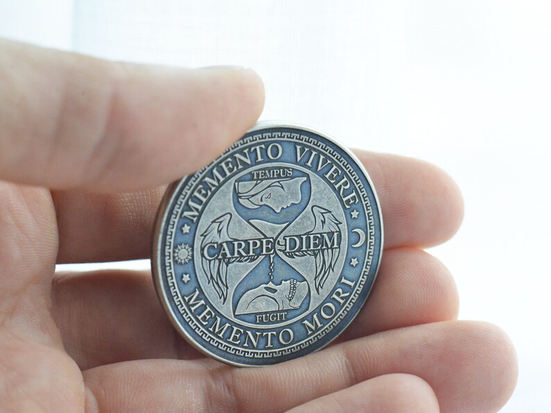 May include: Silver-toned round coin with an hourglass design and the text "Memento Vivere", "Carpe Diem", "Memento Mori", and "Tempus Fugit".