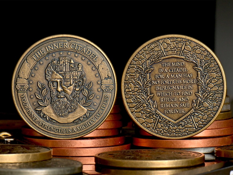 Op de afbeelding: Een ronde, bronskleurige metalen munt met een reli&euml;f van een bebaard figuur met een kasteel in het hoofd aan de ene kant, voorzien van de tekst THE INNER CITADEL en YOUR INNER STRENGTH IS A MIGHTY FORTRESS. De achterzijde toont tekst binnen een krans.